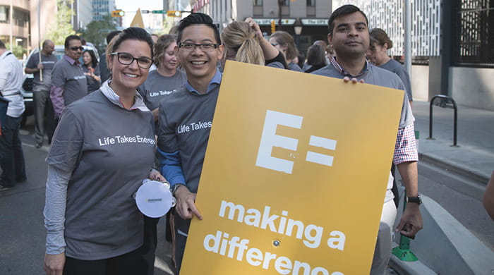 Employees holding a sign at a volunteer event
