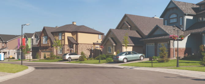 Residential homes in a cul de sac with cars parked in the driveways.