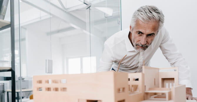 Older man examining an architectural model in an office