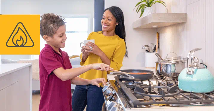 A mother and son cooking on gas stove in kitchen
