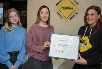 Employees of Powell Contracting smiling and holding up the Enbridge Award of Excellence for Excavating. 