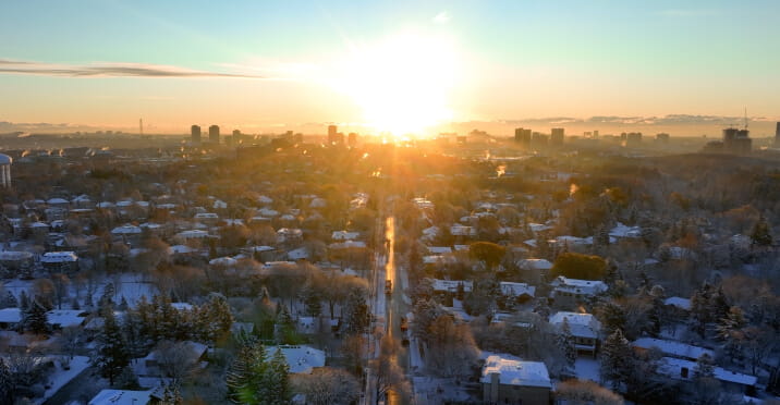Aerial shot of a North York neighbourhood in the winter with the sun in the horizon.