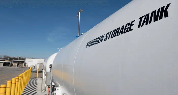 A large hydrogen storage tank outside a building.