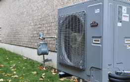 Hybrid heating equipment attached to the outside of a home.