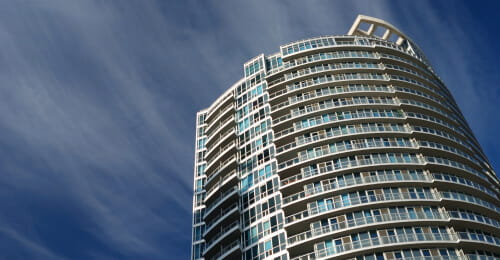 Top floors of a condo tower against the sky.