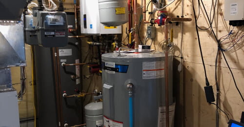 Utility room with a hot water boiler and tank for a home heating system.