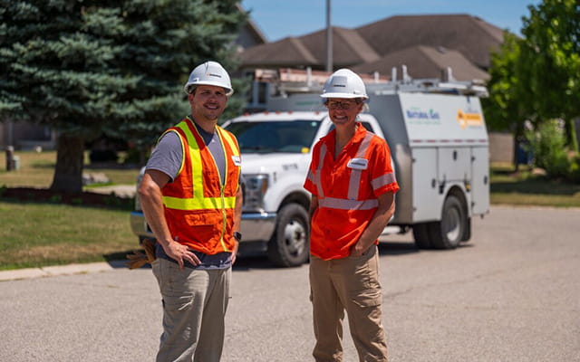Two people wearing safety vests and helmets