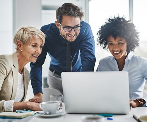 Three people looking at a computer