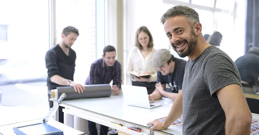 Owner of a small business and his team working.