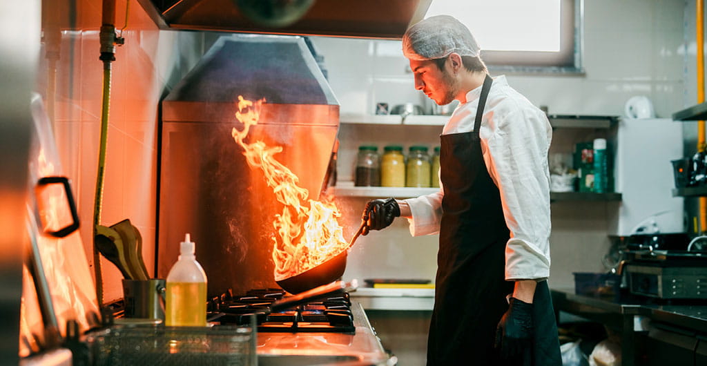Chef cooking over a stove