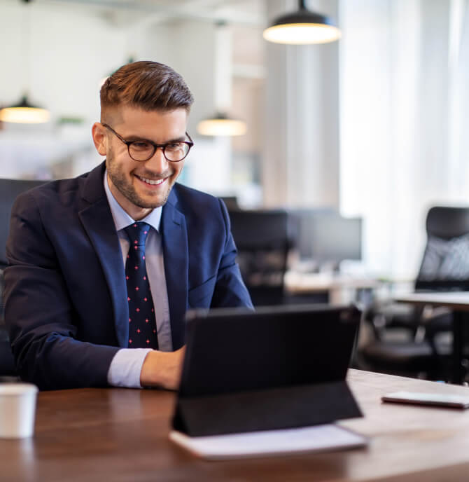 A man looking at his laptop and smiling.