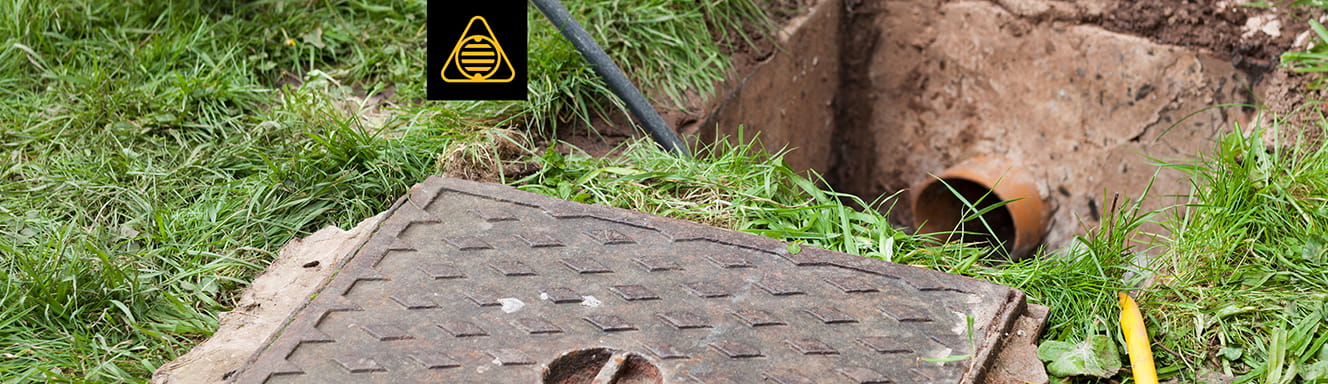 A sewer with grass and a sign.