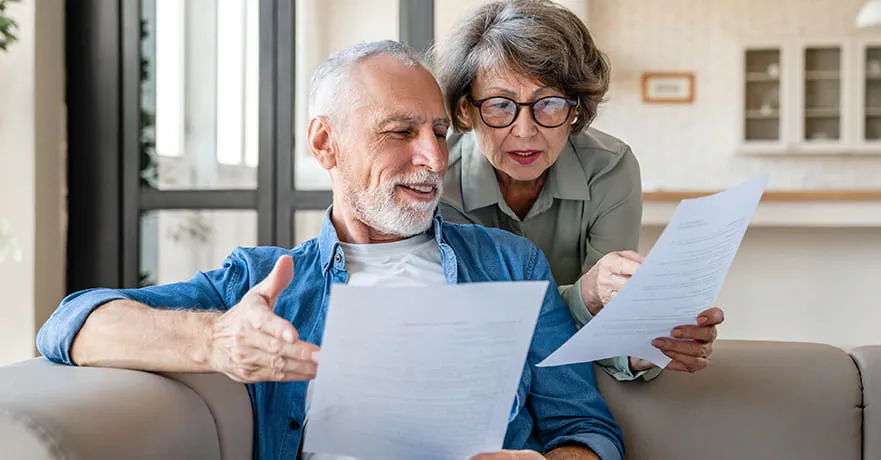 Senior couples reading information on paper.