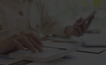 A person using a phone and a calculator.