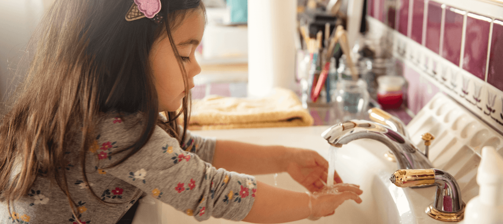 Little girl washing her hands at the sink