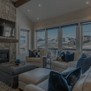 Cozy living room with stone fireplace, flat-screen TV, and natural light for a warm winter ambiance