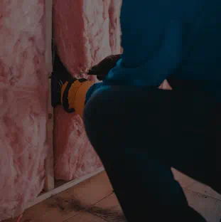 Person installing insulation in a house