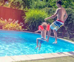 Family jumping into natural gas heated pool